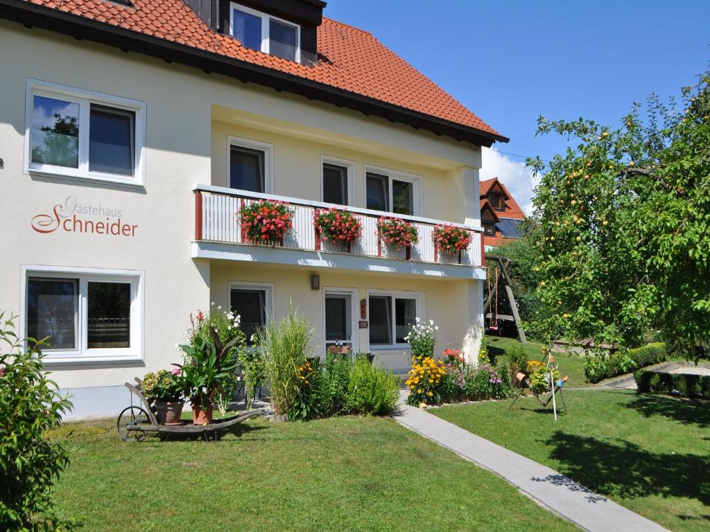 une maison avec un balcon fleuri dans l'établissement Gästehaus Schneider, à Eppishausen