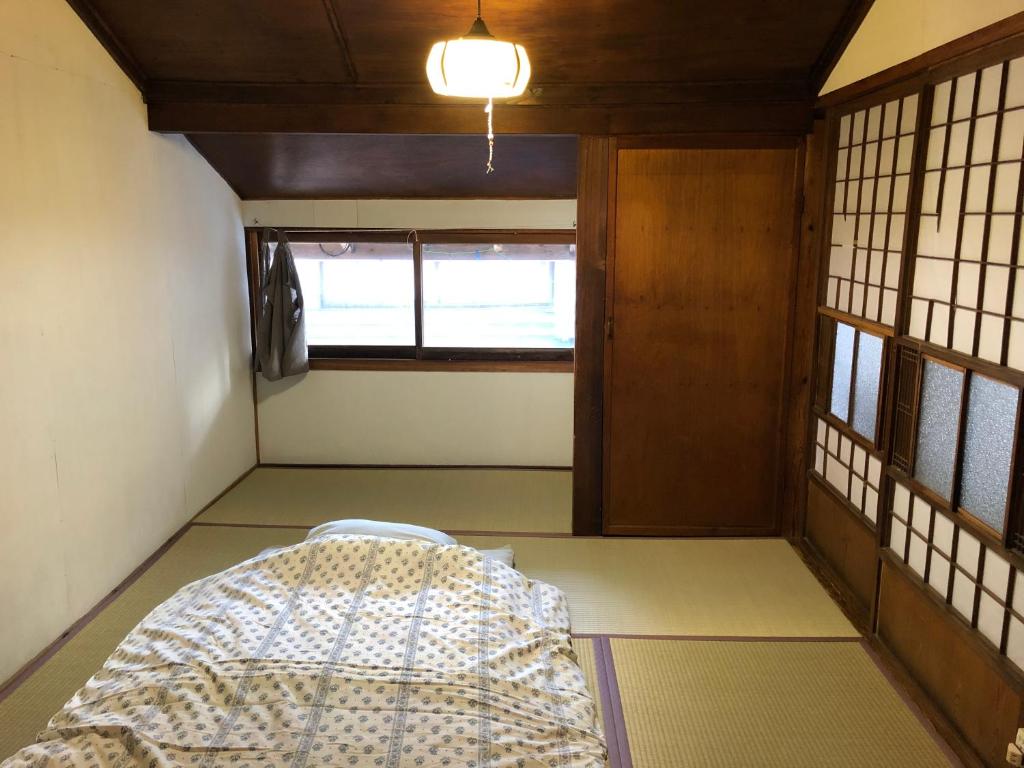 1 dormitorio con 1 cama en una habitación con ventanas en iro, en Sado