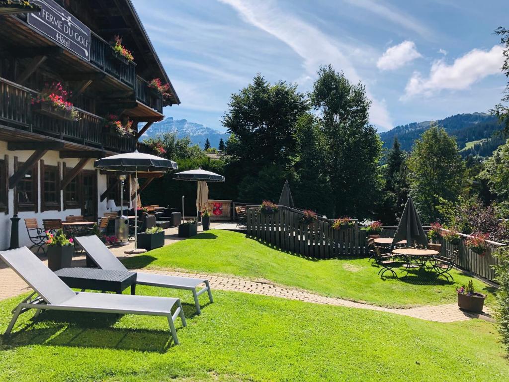 a yard with chairs and tables and a building at La Ferme du Golf in Megève