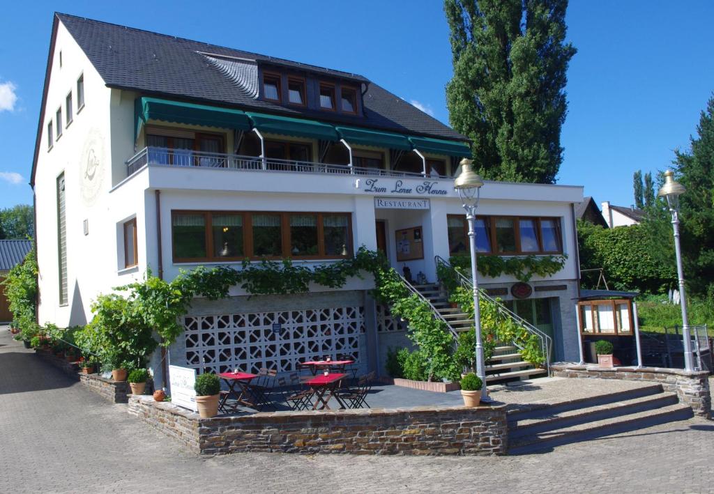 a white house with a table and chairs in front of it at Weinhotel Lenz in Pünderich