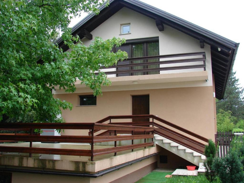 a house with wooden railing and a balcony at Holiday Home by the River Krka in Krška Vas