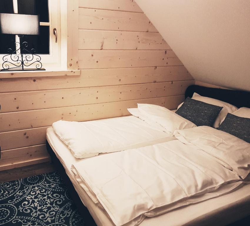 Cama en habitación con pared de madera en Koniakowo - dom Albino en Koniaków