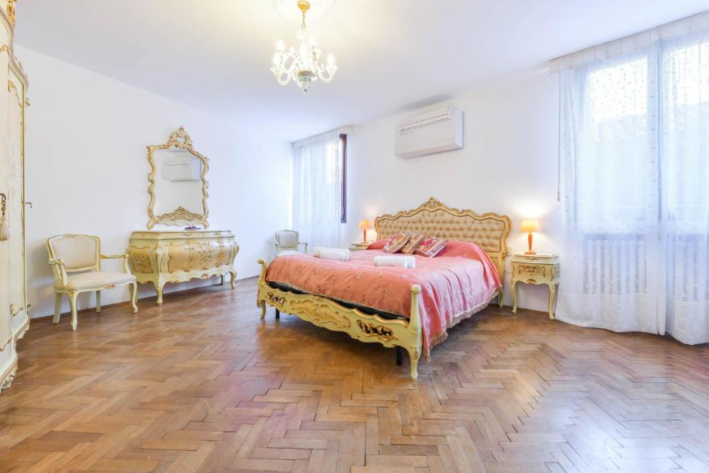 ein großes Schlafzimmer mit einem Bett und einem Kronleuchter in der Unterkunft Ca Virgilio in Venedig