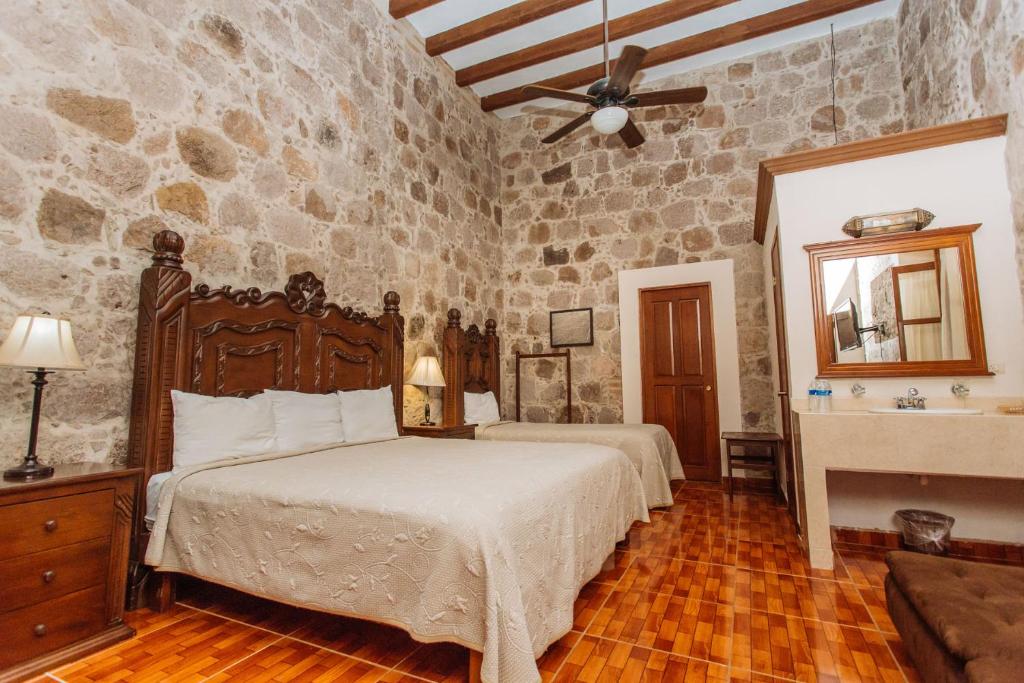 a bedroom with a bed and a stone wall at Mansion Serrano Hotel in El Fuerte