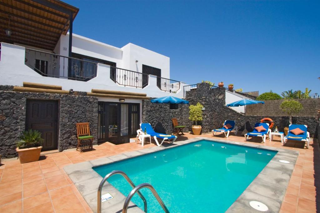 einen Pool vor einer Villa in der Unterkunft 4 bedroom Villa Saturn with private heated pool in Puerto del Carmen