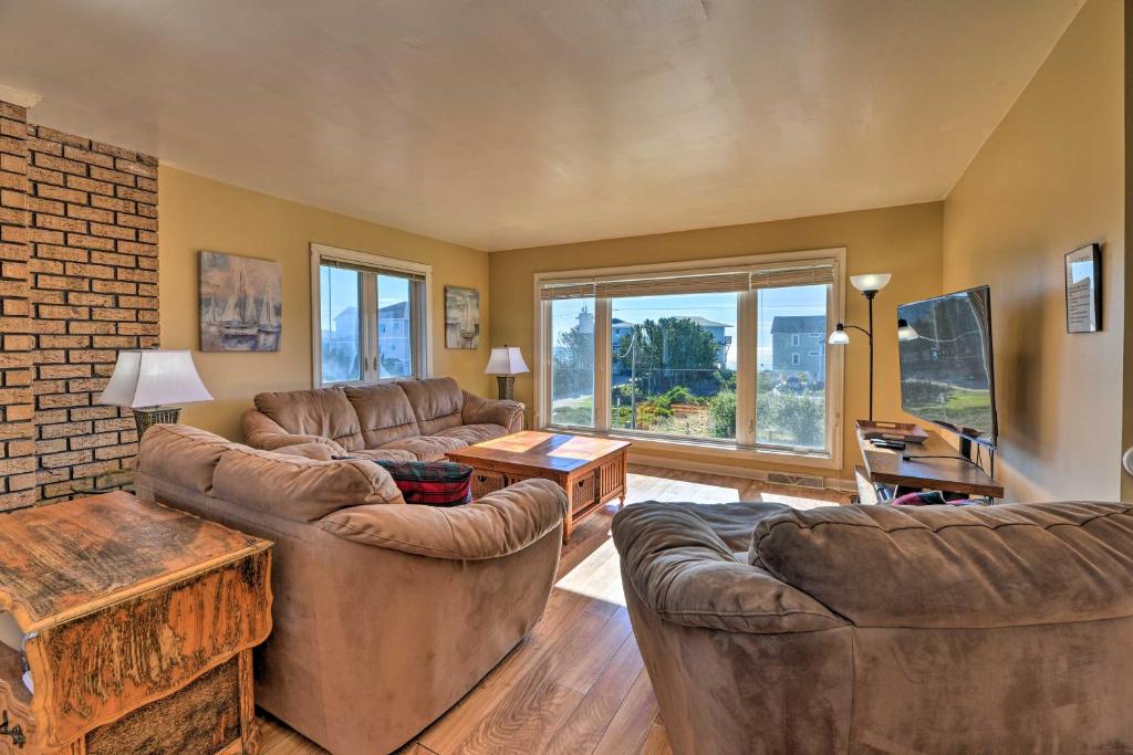 a living room with couches and a brick wall at East of the Sun Beachside Apartment with Deck! in Emerald Isle