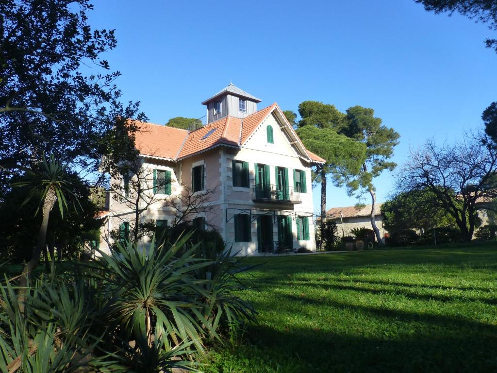 a large white house with a grass yard at La Maison du Môle in Aigues-Mortes