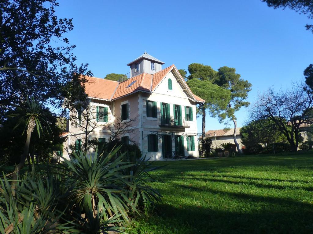 ein großes weißes Haus mit einem Rasenhof in der Unterkunft La Maison du Môle in Aigues-Mortes