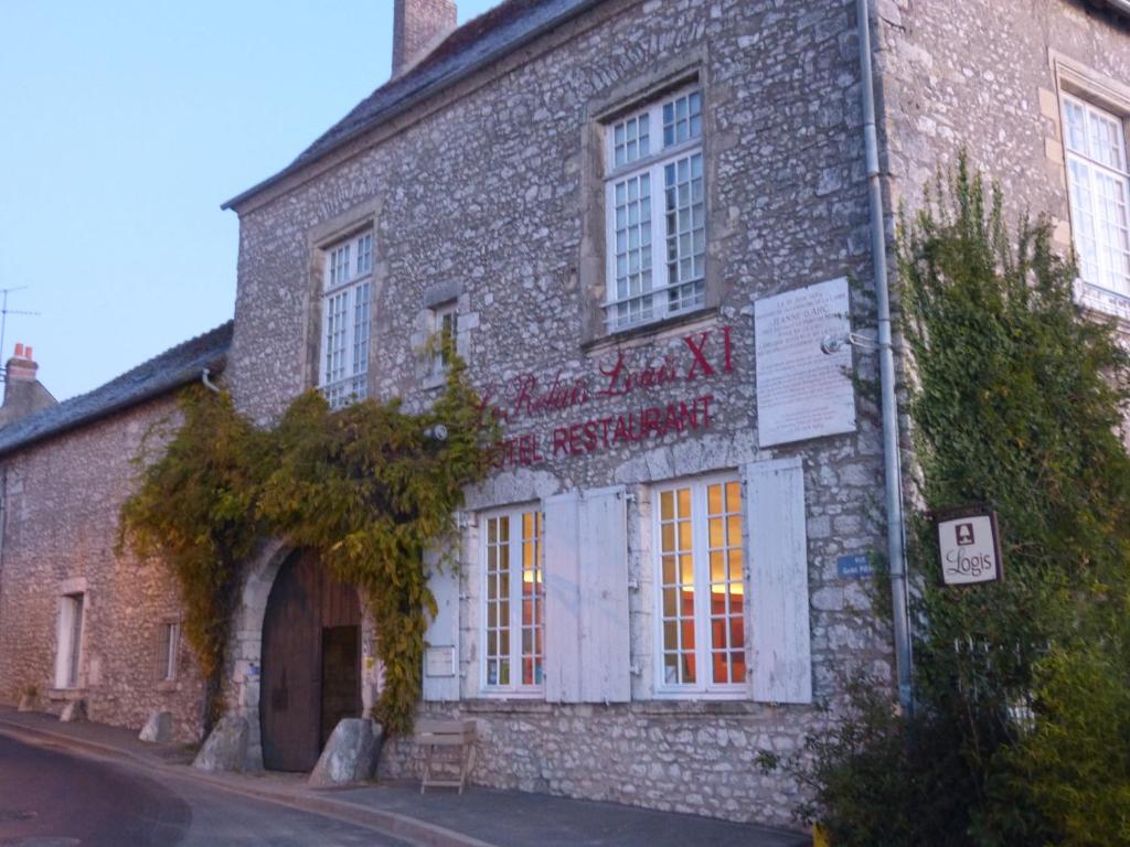 ein altes Backsteingebäude mit einem Schild drauf in der Unterkunft Logis Hôtel Le Relais Louis XI in Meung-sur-Loire