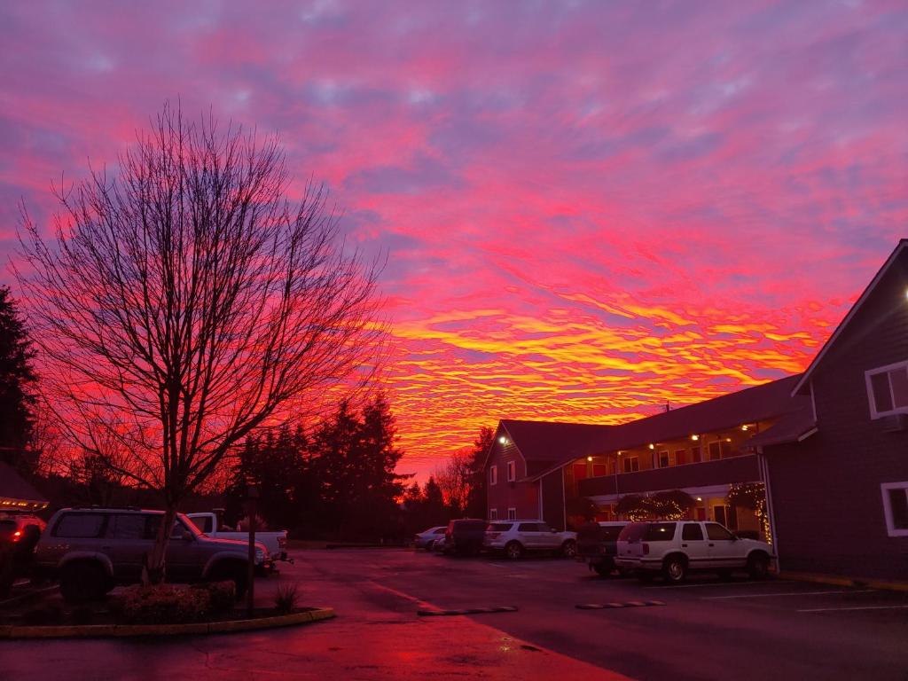 una puesta de sol con coches estacionados en un estacionamiento en Snohomish Inn, en Snohomish