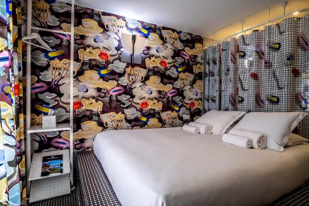 a bedroom with a bed with a wall covered in stuffed animals at Hôtel La Reine Jane in Hyères