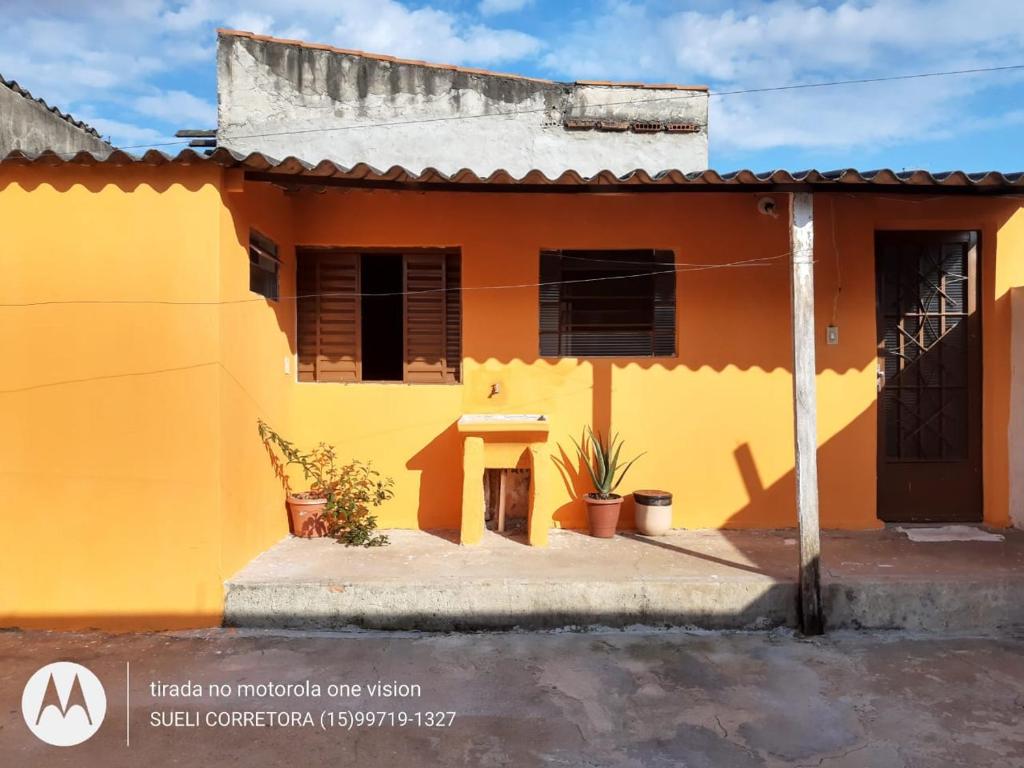 une maison jaune avec une table devant elle dans l'établissement Edícula. Ent.independente, à Sorocaba