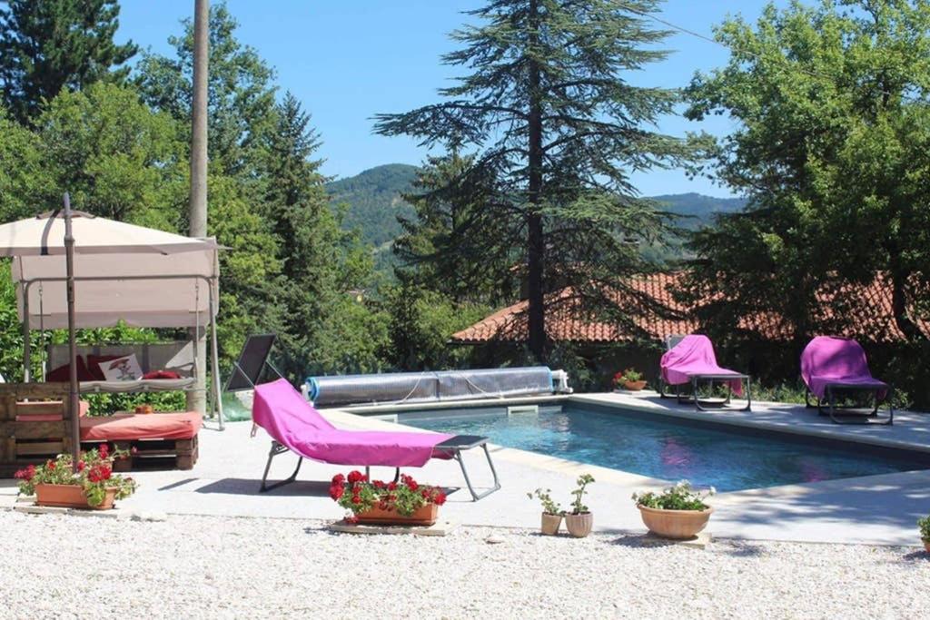 una piscina con sillas rosas junto a un poolvisor rosa en Casa Lilu, Pietralunga, Umbria, en Pietralunga