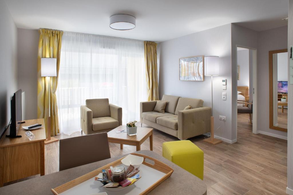 聖康坦的住宿－DOMITYS - Les Papillons d'Azur，客厅配有沙发和桌子