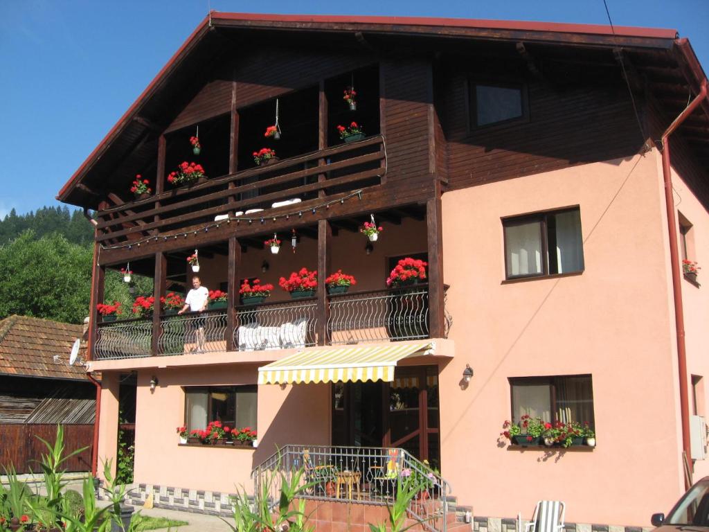 una casa con flores en el balcón en Pensiune Maria, en Rucăr