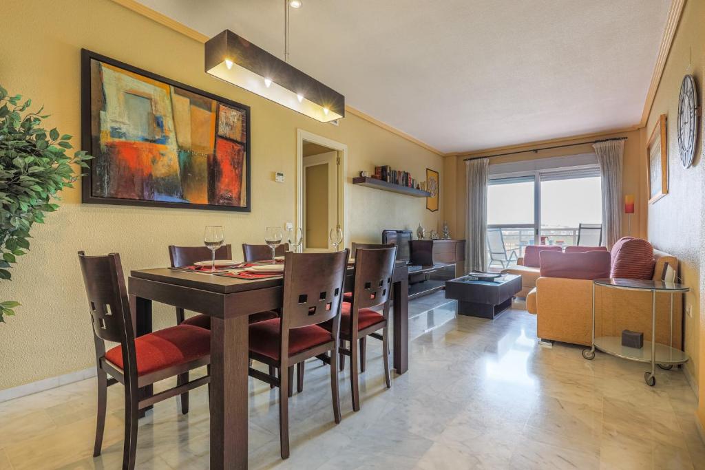 a dining room with a table and chairs and a living room at Sensacional Apt 2 Hab 2 baños 4 pax Aljarafe Metro in San Juan de Aznalfarache