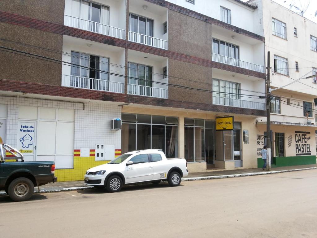 une voiture blanche garée devant un bâtiment dans l'établissement HOTEL PINOTTI LTDA, à Curitibanos