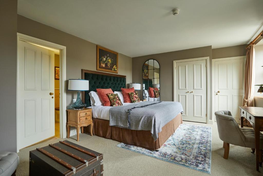 a bedroom with a bed and a table and a chair at The Methuen Arms in Corsham