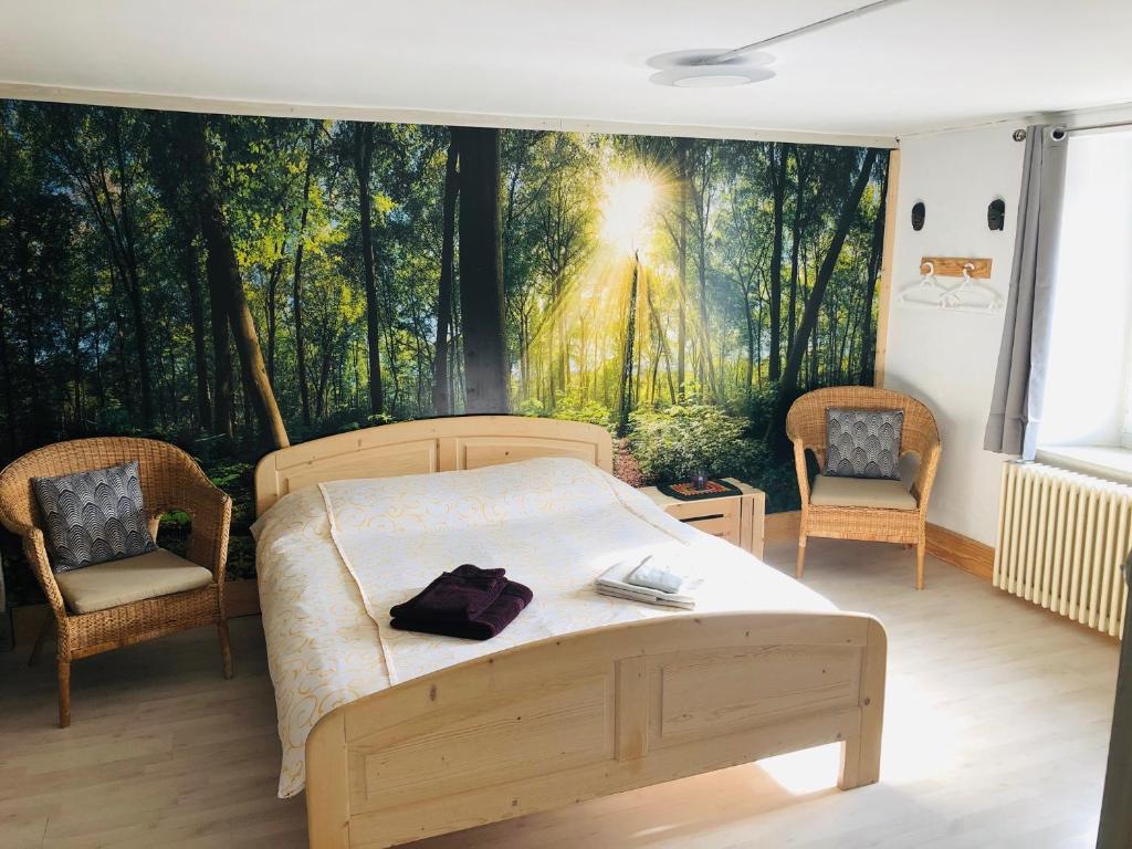 a bedroom with a bed in front of a forest mural at LE 13, Charmant appartement de 2 pièces à Lignerolle in Lignerolle