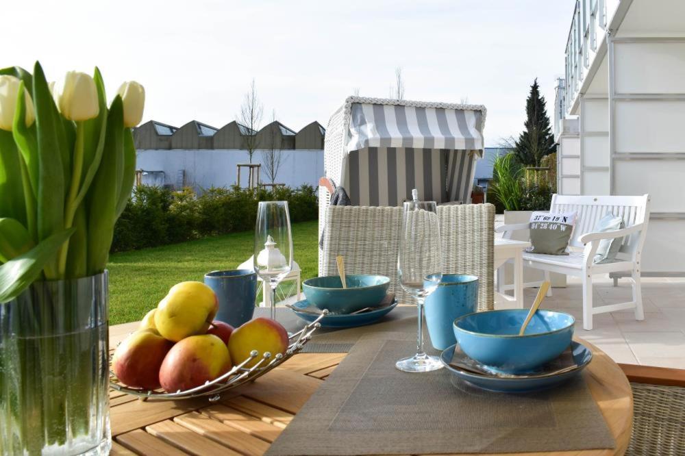 a wooden table with bowls of fruit and wine glasses at Ferienwohnung Ausruhen in Timmendorfer Strand