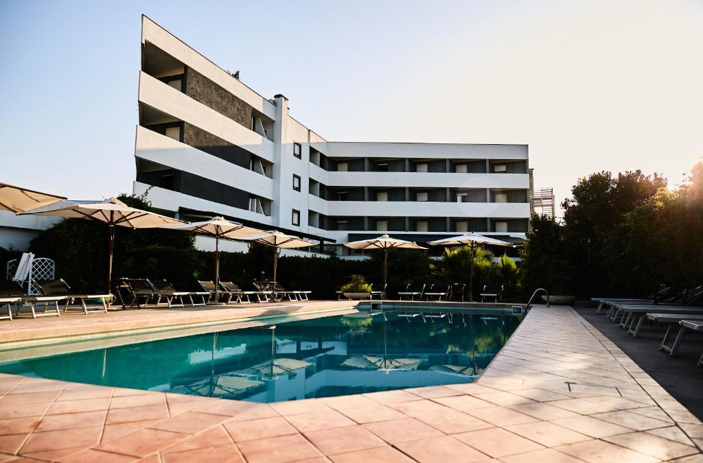 a hotel with a swimming pool in front of a building at Hotel Enterprise in Montalto di Castro