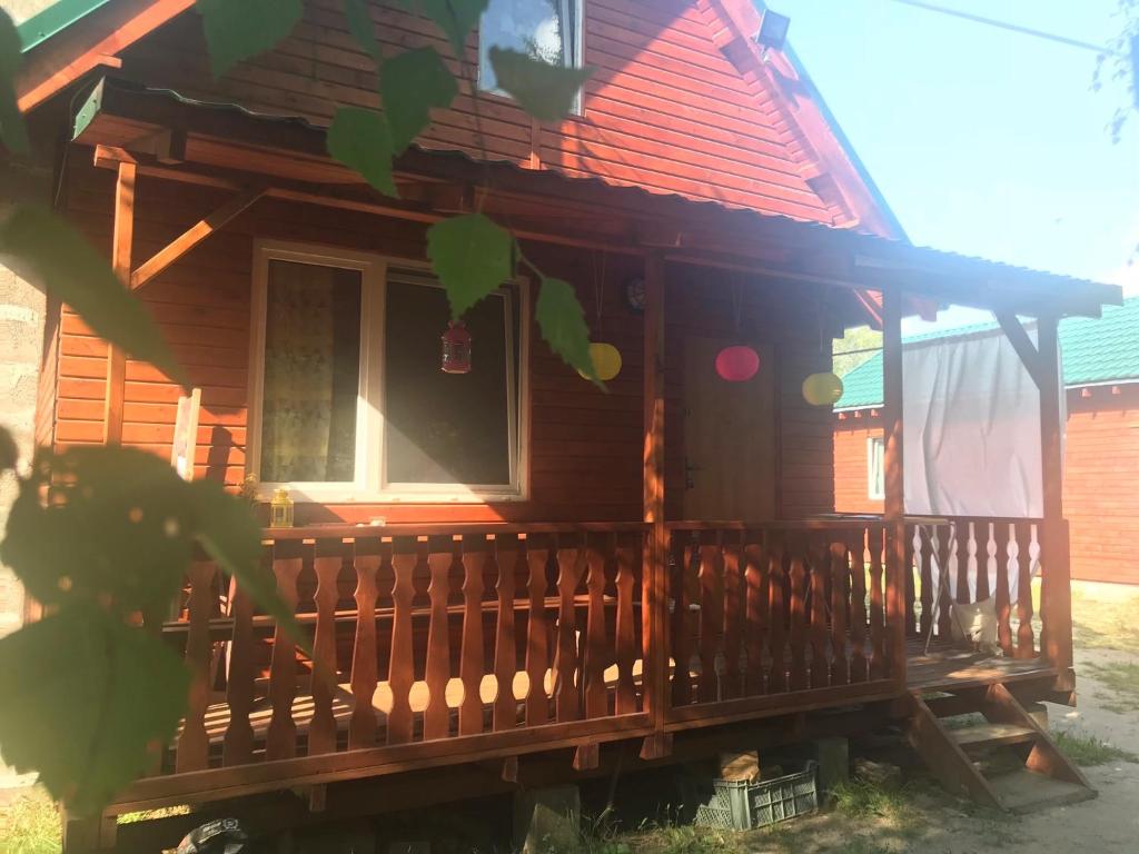 ein Holzhaus mit einem Zaun davor in der Unterkunft Domki na łowisku Admar w Dąbiu Lubuskim in Dąbie