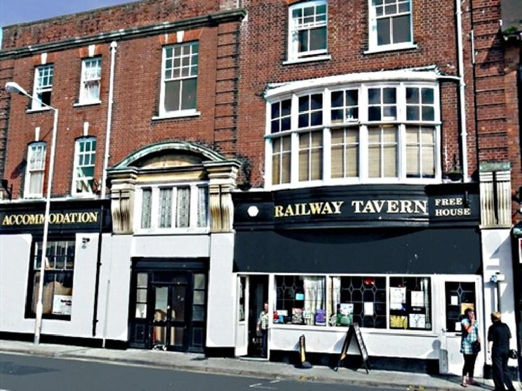 a building on a street with people walking in front of it at Clifton Hotel in Weymouth