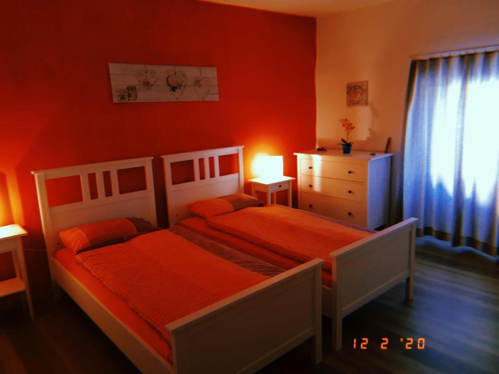 a bedroom with two beds and a dresser and a window at Ca da la nona in Cavigliano