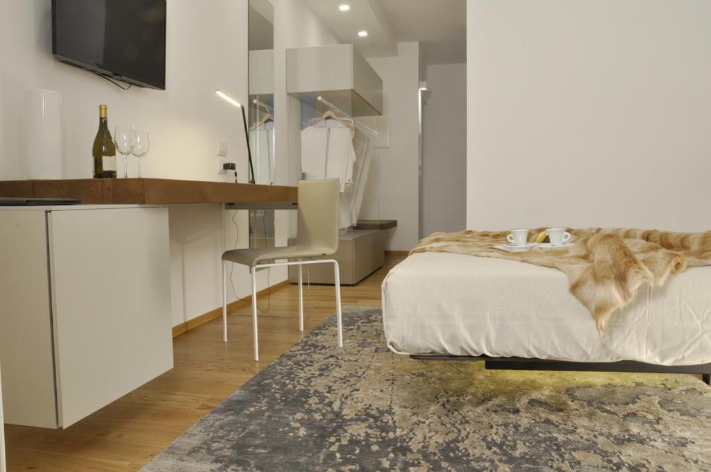 1 dormitorio con cama, mesa y escritorio en Chiaroscuro, en Belforte del Chienti