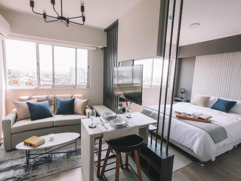 een slaapkamer met een bed, een bank en een tafel bij Trendy Host Connect, Barranco in Lima