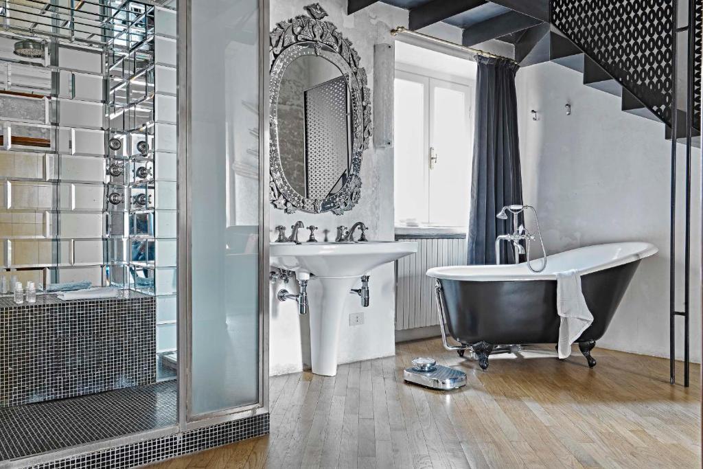 łazienka z wanną, umywalką i lustrem w obiekcie G-Rough, Rome, a Member of Design Hotels w Rzymie