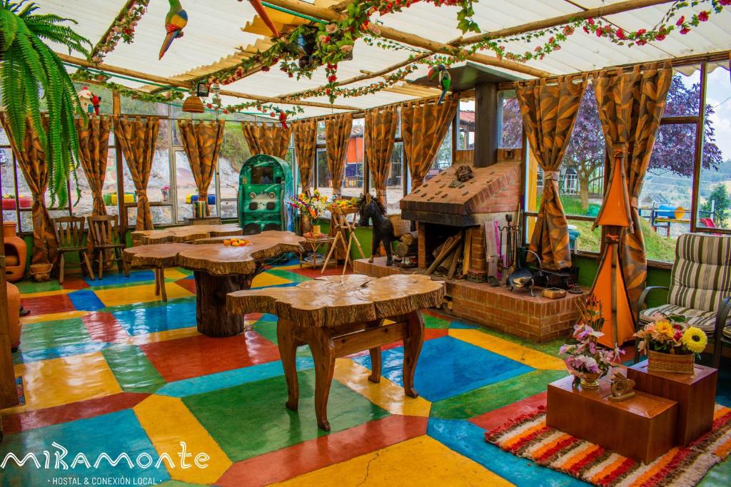 una stanza con pavimento colorato e tavoli di Miramonte Hostal a Paipa