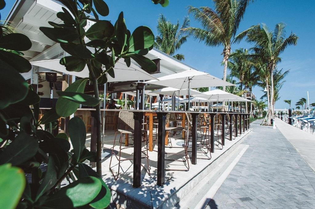 a row of tables with white umbrellas on a beach at The Perry Hotel & Marina Key West in Key West