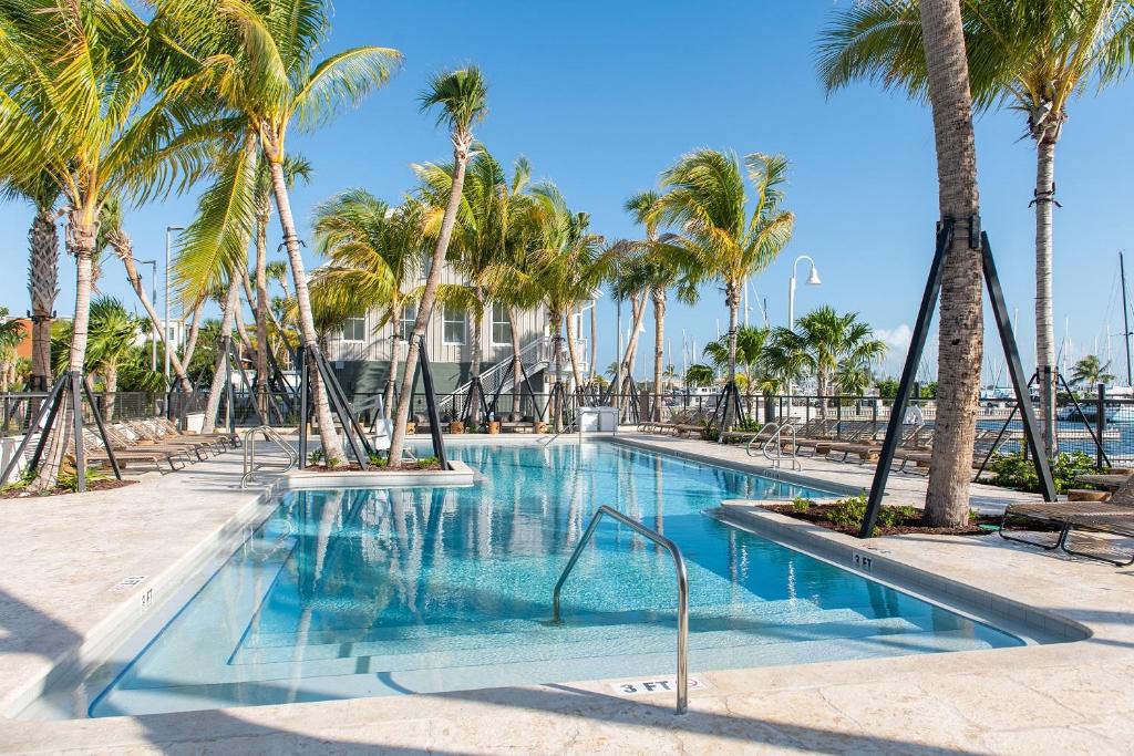 a swimming pool with palm trees in a resort at The Perry Hotel & Marina Key West in Key West