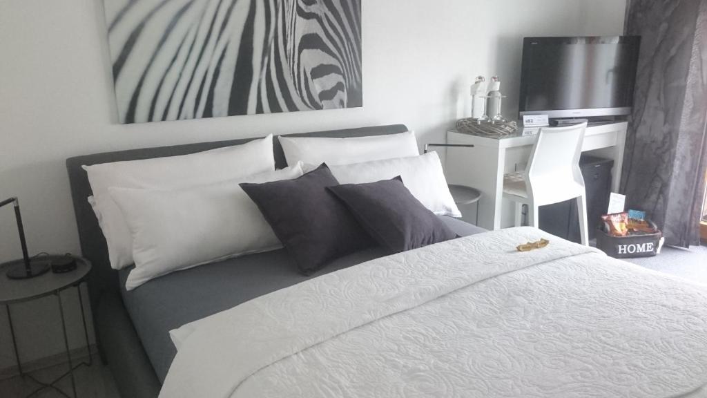 a bedroom with a bed with white sheets and pillows at K82 BNB & Hotel in Kirchentellinsfurt
