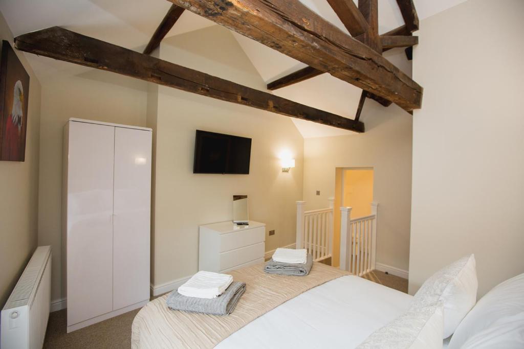 a bedroom with a bed and a tv on the wall at THE SPREAD EAGLE chesterfield in Chesterfield