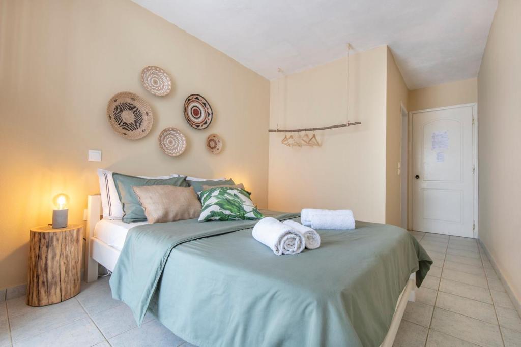 1 dormitorio con 1 cama con toallas en Puerto Seaside Rooms, en Akhladherí
