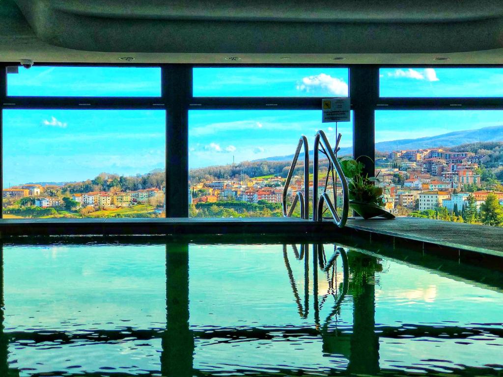 einen Pool mit Blick auf das Wasser in der Unterkunft Grand Hotel Ambasciatori Wellness & Spa in Chianciano Terme