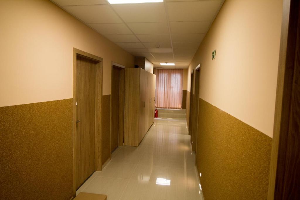 un couloir vide dans un immeuble de bureaux avec un long couloir dans l'établissement M7 Galéria Panzió, à Letenye