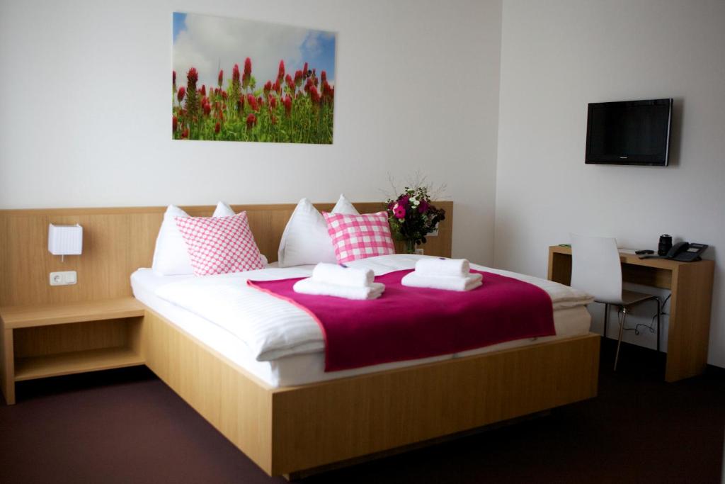 Kapellerhof في Stadl-Paura: غرفة نوم بسرير كبير مع وسائد وردية وبيضاء