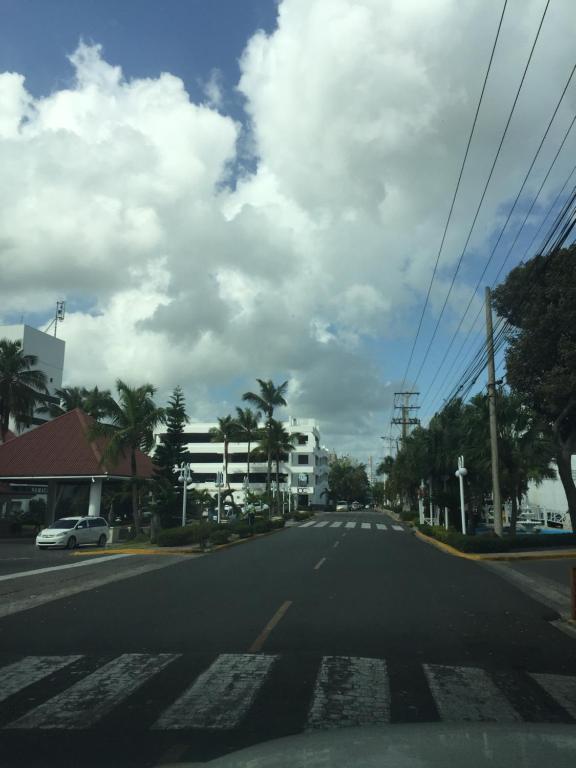 una calle vacía con un cielo nublado y palmeras en Terrazas del Caribe, Boca Chica., en Boca Chica