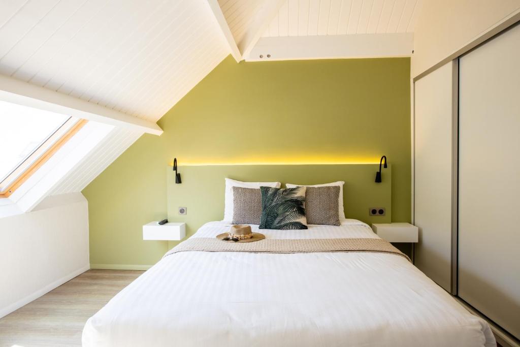 a bedroom with a large bed with a yellow wall at Centr'Hotel in Marigot