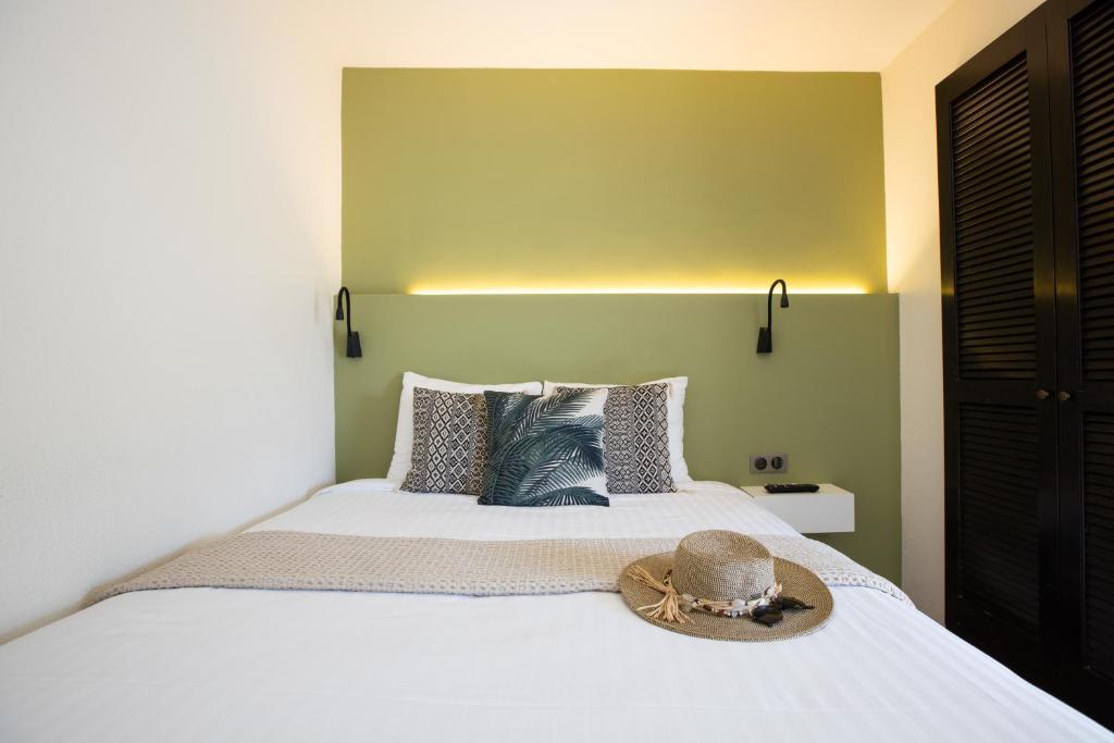 a bedroom with a bed with a hat on it at Centr'Hotel in Marigot