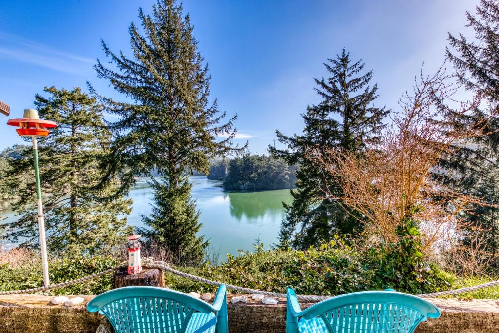 a view of a lake from a yard with two chairs at Osprey Cove in Barview