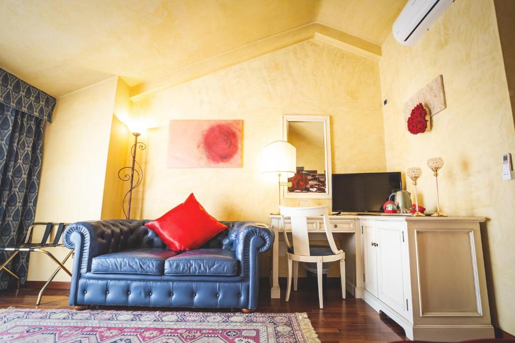 a living room with a blue couch and a desk at Hotel Posta in Cecina