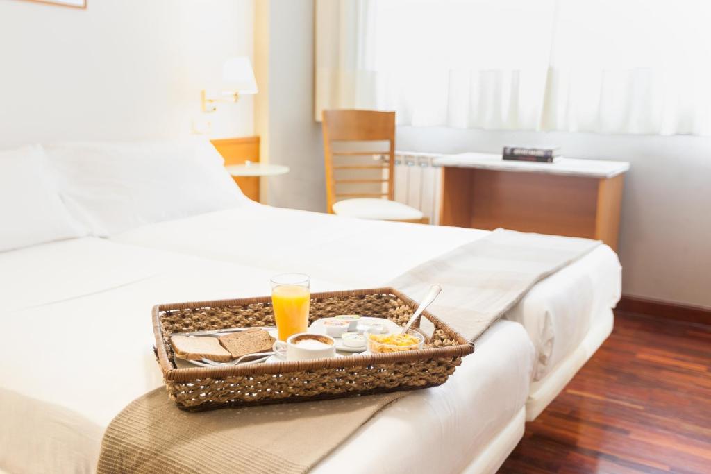 een dienblad met eten op de rand van een bed bij Zumaia Hotela in Zumaia