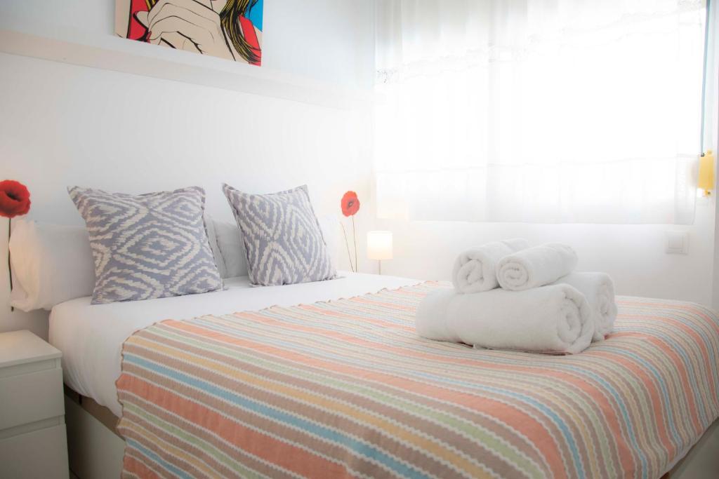 um quarto com uma cama com toalhas em MONKÓ - ROSARIO APARTMENT BEACH & SUN o em Torremolinos