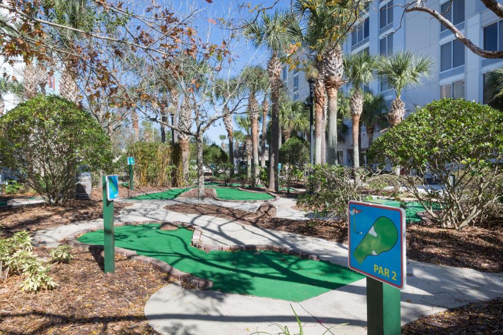 a golf course in a park with trees and a building at Holiday Inn Express & Suites S Lake Buena Vista by IHG in Kissimmee