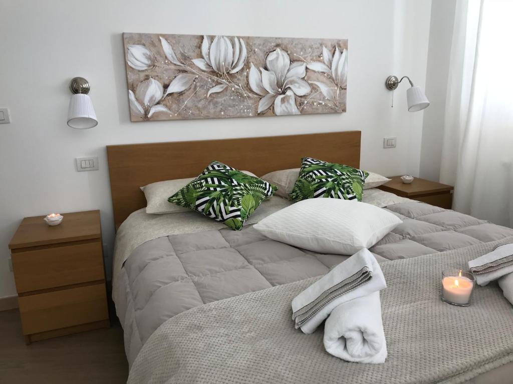 a bedroom with two beds with towels and a painting on the wall at GiorGiada Relax in Castelmola
