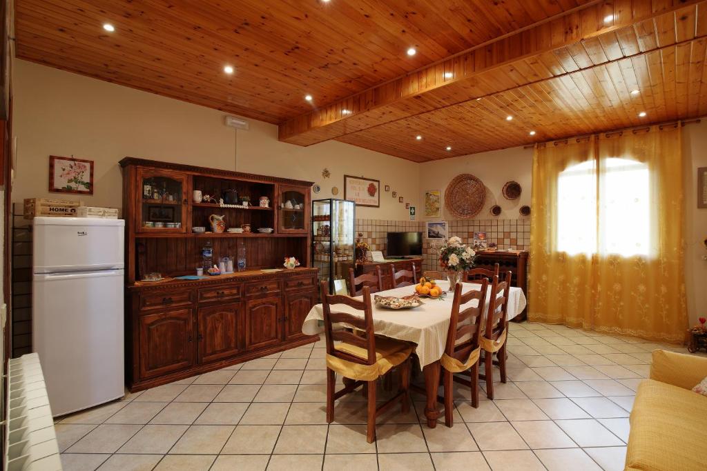 a kitchen and dining room with a table and a refrigerator at B&B Le Tre rose dell'Etna in Zafferana Etnea